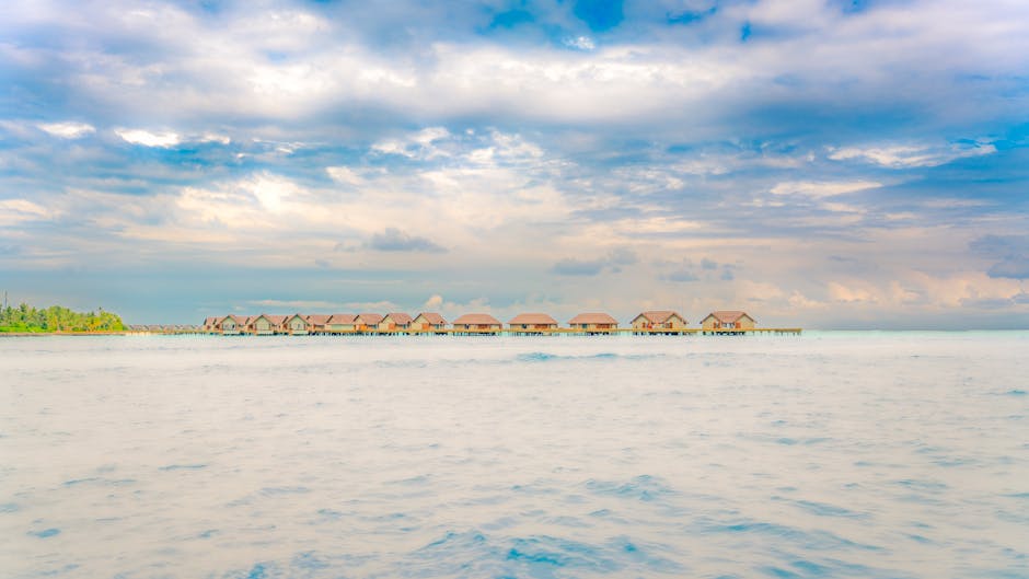 Idyllic overwater bungalows on a calm ocean with a vibrant sky in Maldives.