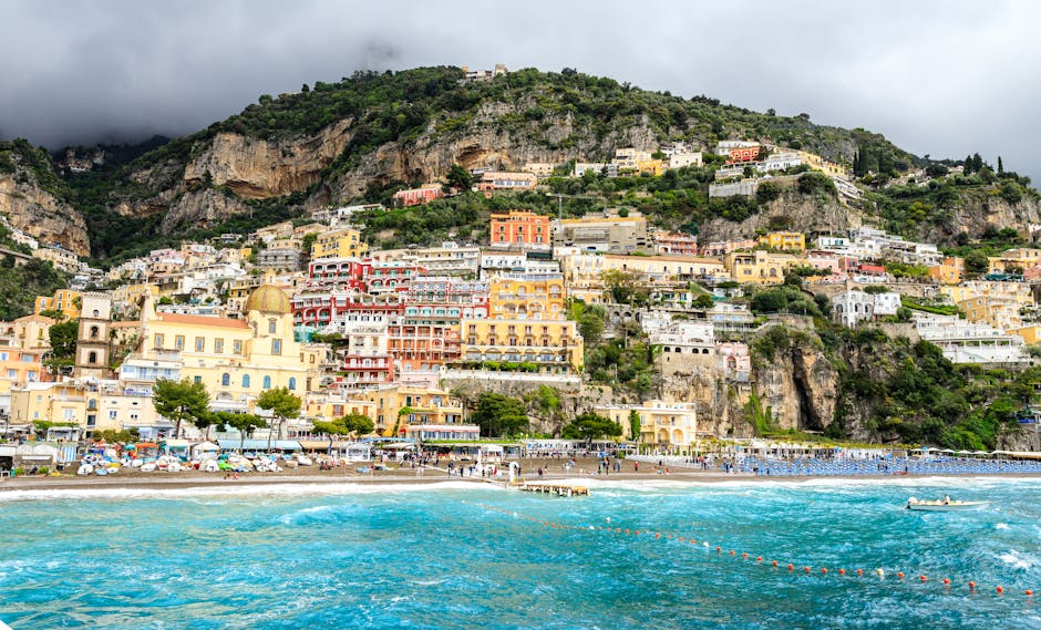 Vibrant seaside view of Positano's colorful hillside buildings overlooking the Mediterranean Sea.