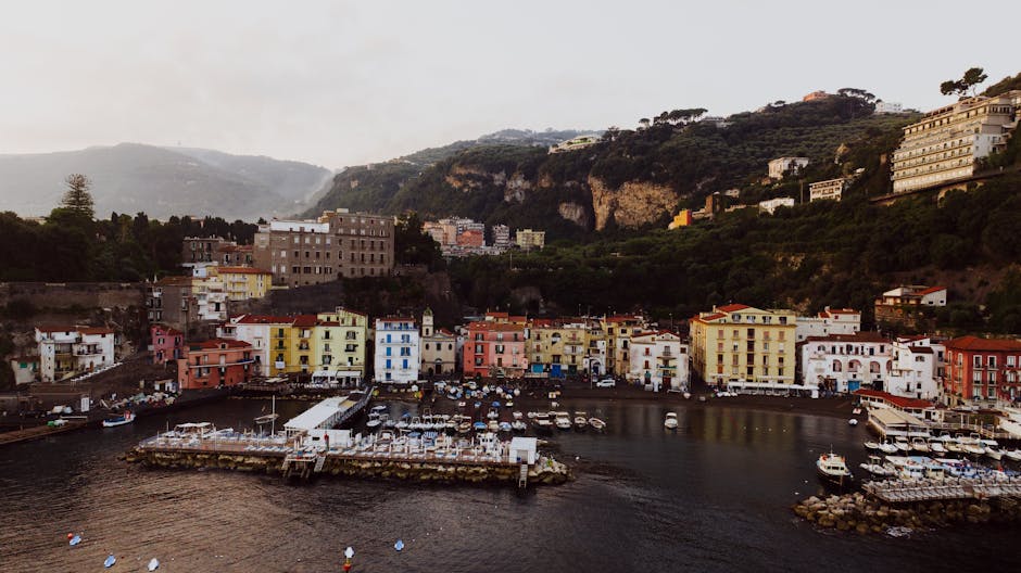 Explore the picturesque coastal town of Sorrento, Italy with its colorful buildings and serene marina.